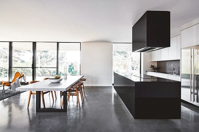 A burnished concrete floor finish throughout a kitchen and open plan living area in Canberra.